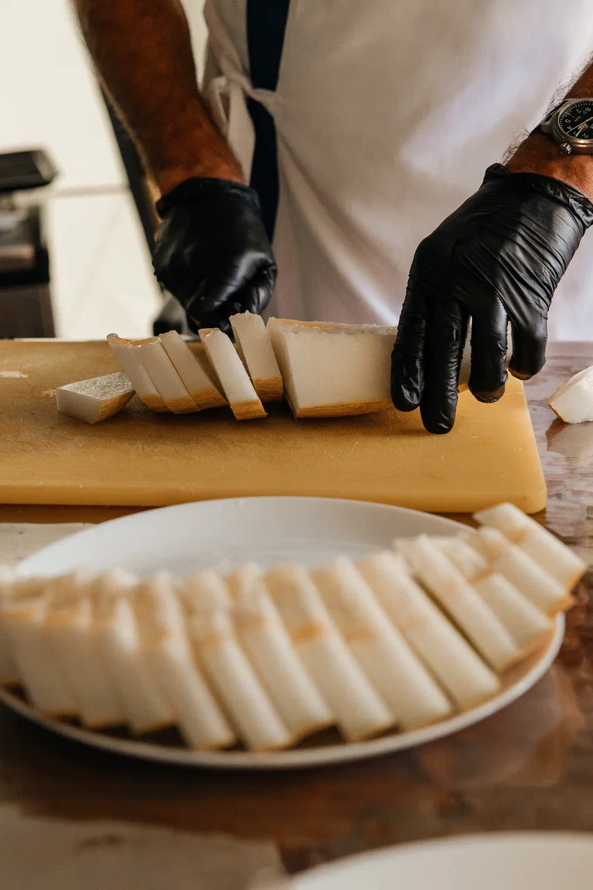 Шеф-повар нарезает свежий гребешок на разделочной доске, гастро-тур на Сахалине
