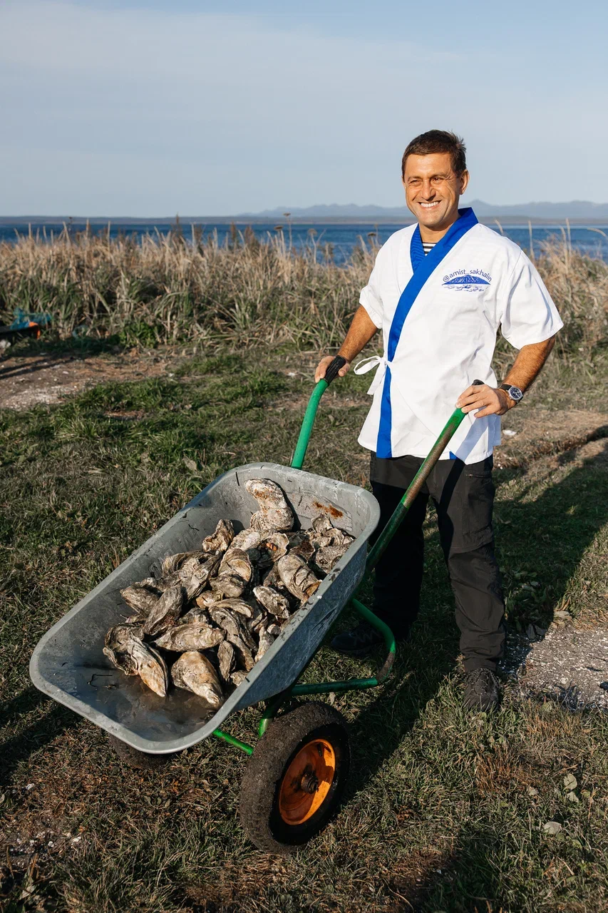 Шеф-повар АМИСТ с тачкой свежих устриц на берегу лагуны Буссе, Сахалин