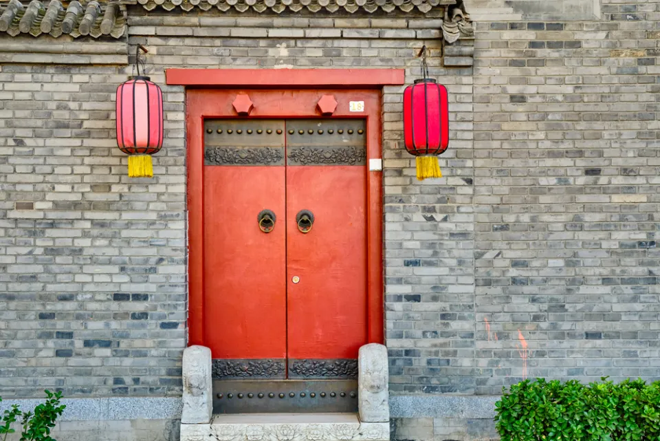 Traditional Beijing hutong — an old doorway with red lanterns in a historic district