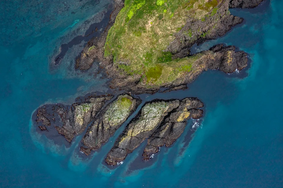 Columnar basalt stacks of the Moneron marine reserve — aerial drone shot