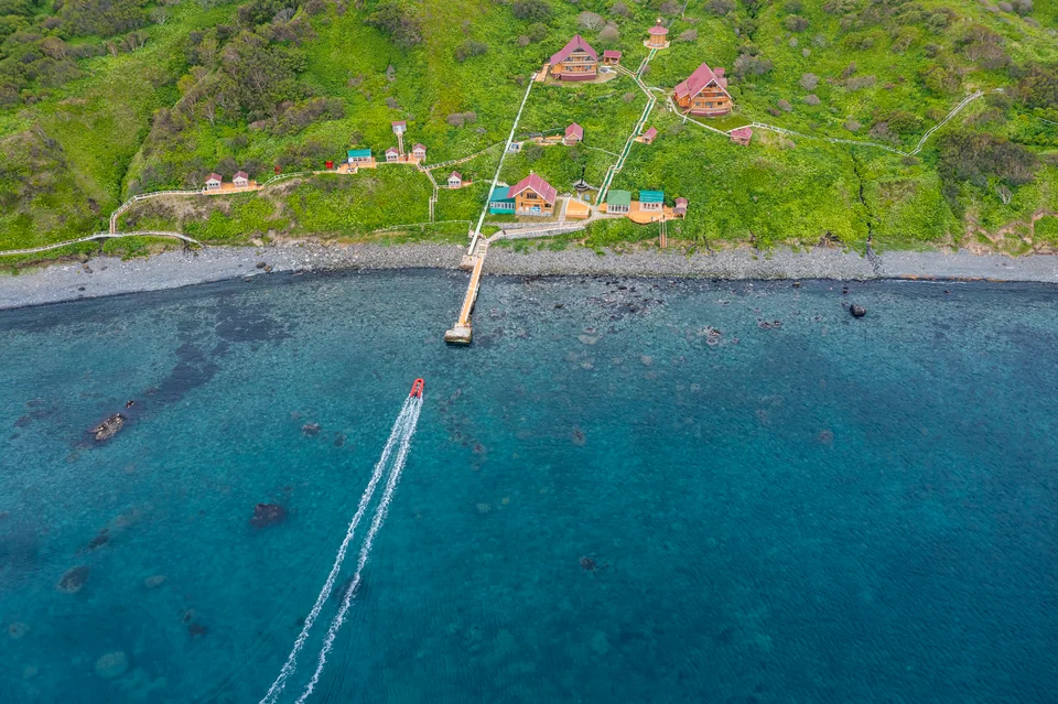 Pier and motor launch at Moneron's western shore — tender transfer from the ship